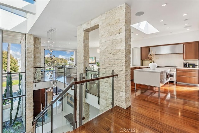 hallway featuring hardwood / wood-style flooring and a skylight