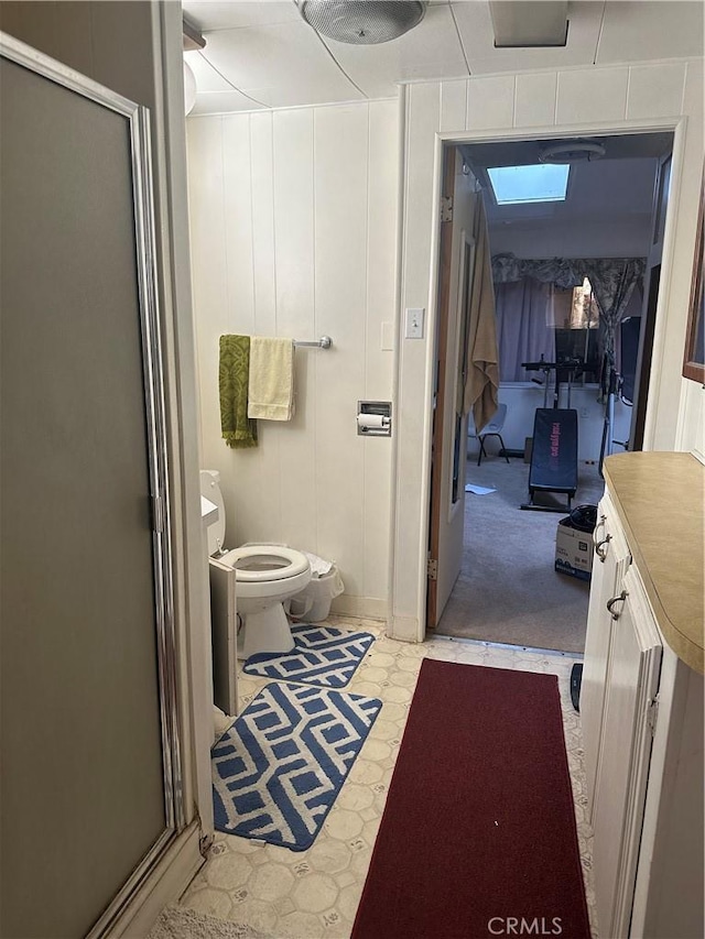 bathroom featuring toilet, vanity, and walk in shower