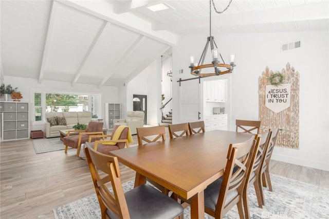 dining space with beamed ceiling, a chandelier, and light hardwood / wood-style flooring