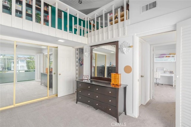 bedroom with light carpet and a high ceiling