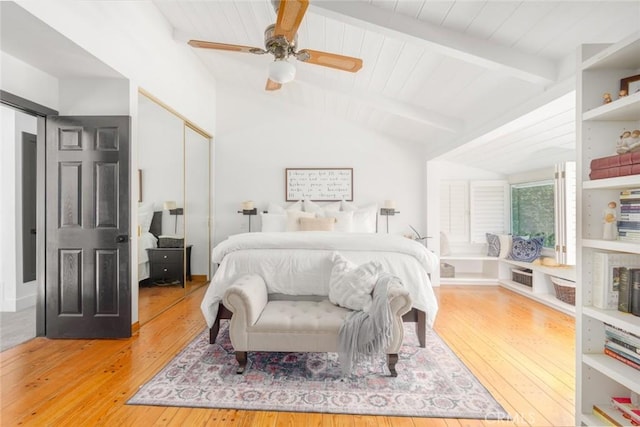 bedroom featuring ceiling fan, wood-type flooring, lofted ceiling with beams, and a closet