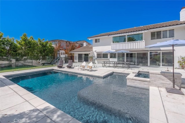 rear view of house featuring a patio and a balcony