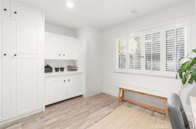 bar with white cabinetry and light hardwood / wood-style flooring