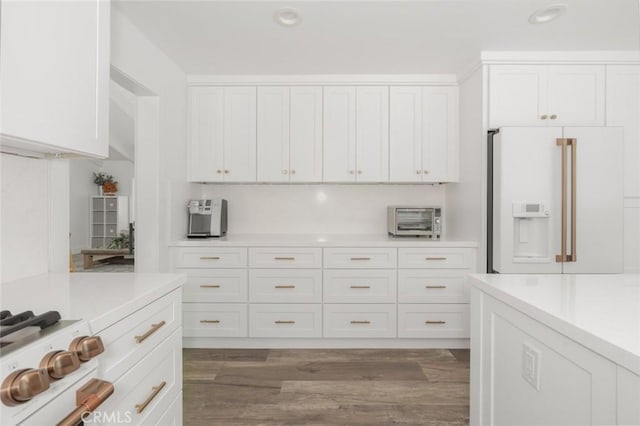 kitchen featuring white cabinetry, dark hardwood / wood-style floors, and white refrigerator with ice dispenser