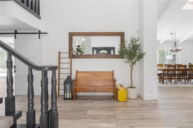 interior space featuring wood ceiling, an inviting chandelier, wood-type flooring, beamed ceiling, and a barn door