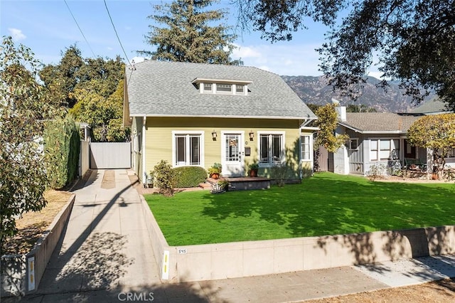 bungalow-style home with a mountain view and a front lawn