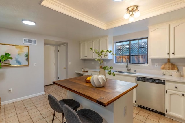 kitchen with light tile patterned flooring, sink, white cabinets, stainless steel dishwasher, and a raised ceiling