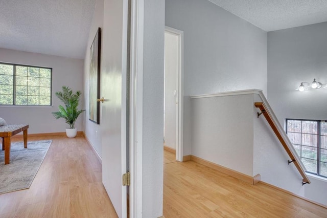 hall featuring a textured ceiling and light wood-type flooring