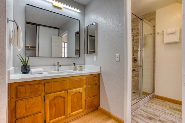 bathroom featuring vanity, a shower with shower door, and wood-type flooring