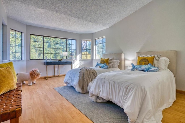 bedroom with hardwood / wood-style floors and a textured ceiling