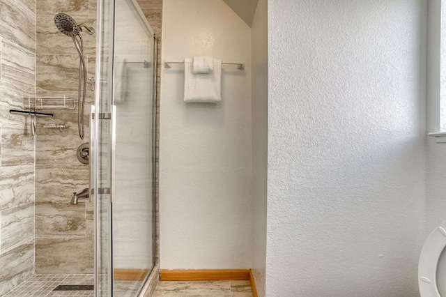 bathroom featuring a shower with shower door