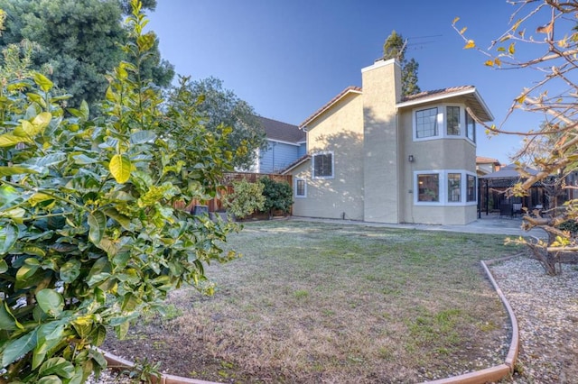 rear view of property with a yard and a patio area