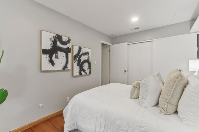 bedroom with hardwood / wood-style floors and a closet