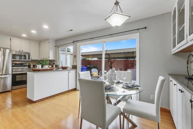 dining room featuring sink and light hardwood / wood-style floors