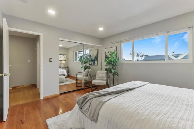 bedroom with multiple windows, hardwood / wood-style flooring, and a closet