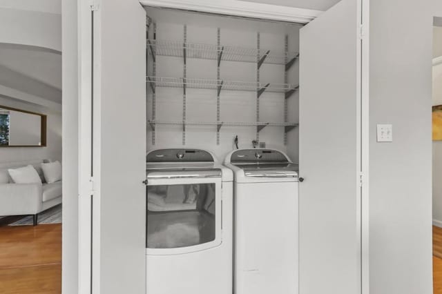 laundry room featuring hardwood / wood-style flooring and washer and clothes dryer