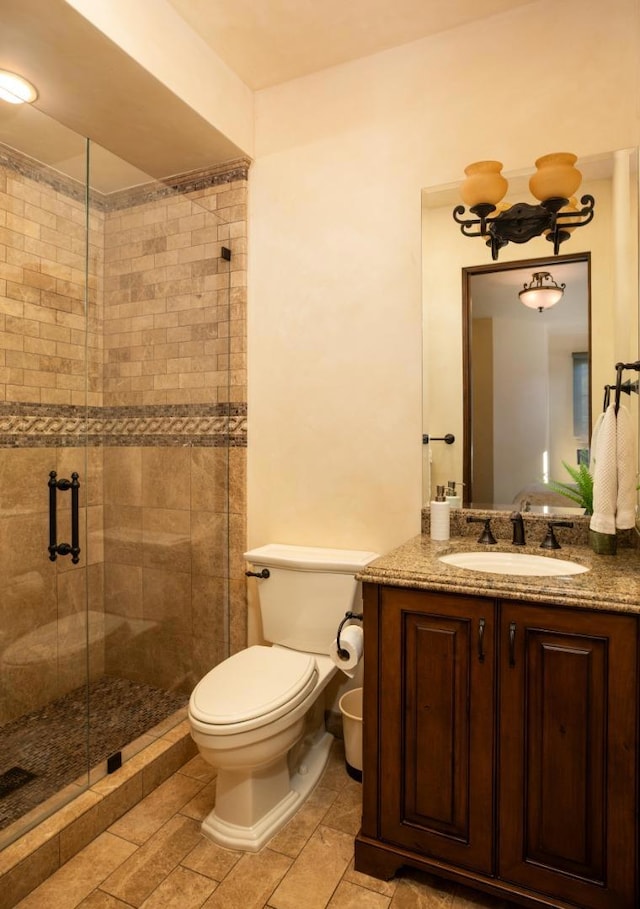 bathroom featuring vanity, toilet, and a shower with shower door