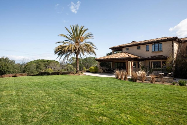 back of property featuring a patio area and a lawn