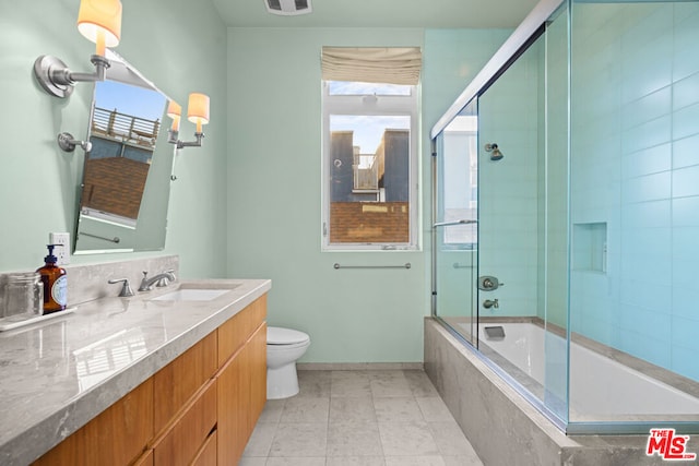 full bathroom featuring enclosed tub / shower combo, vanity, and toilet