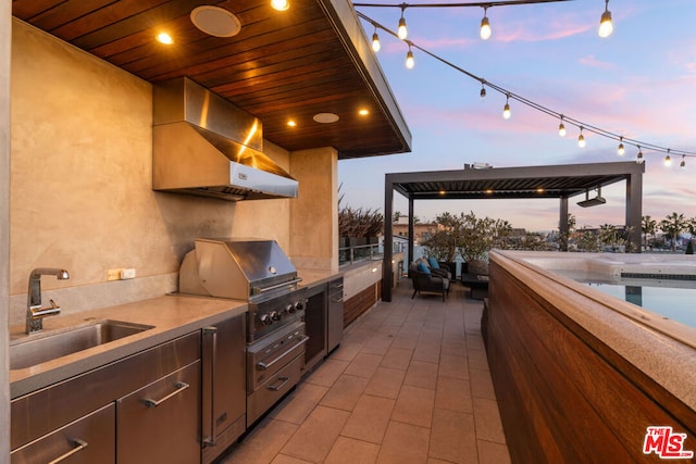 patio terrace at dusk featuring a pool, area for grilling, grilling area, and sink