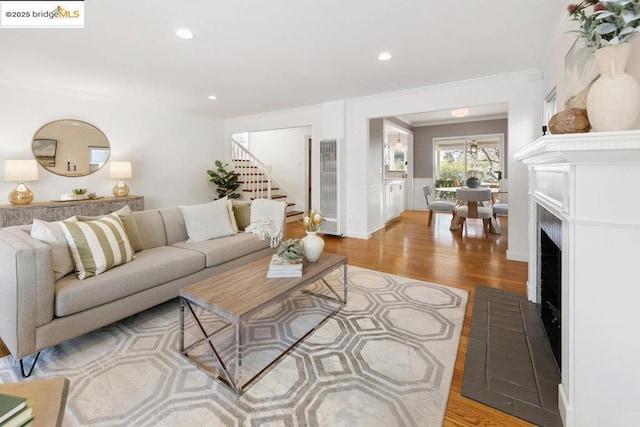 living room with crown molding and light hardwood / wood-style floors