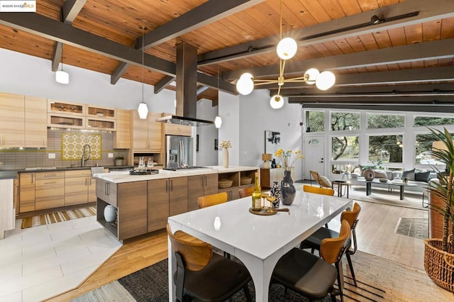 kitchen featuring beamed ceiling, a center island, pendant lighting, and light hardwood / wood-style flooring