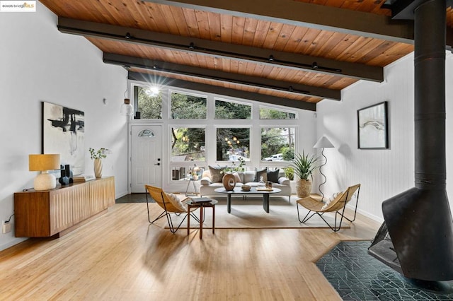 living room featuring beam ceiling, wood ceiling, hardwood / wood-style flooring, and a wood stove