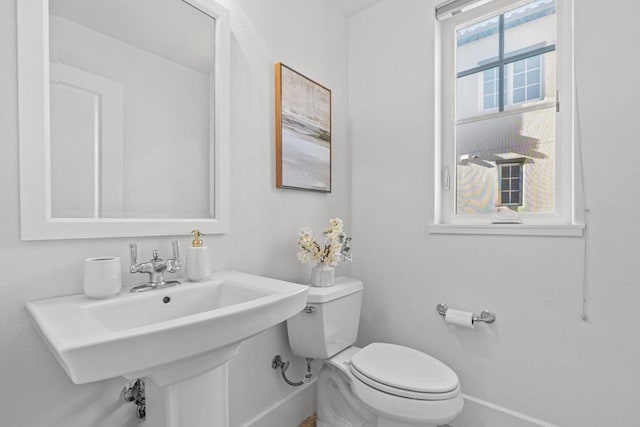 bathroom featuring a healthy amount of sunlight, toilet, and sink