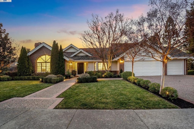 view of front of property with a garage and a yard