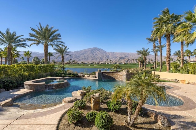 view of pool with a mountain view and an in ground hot tub