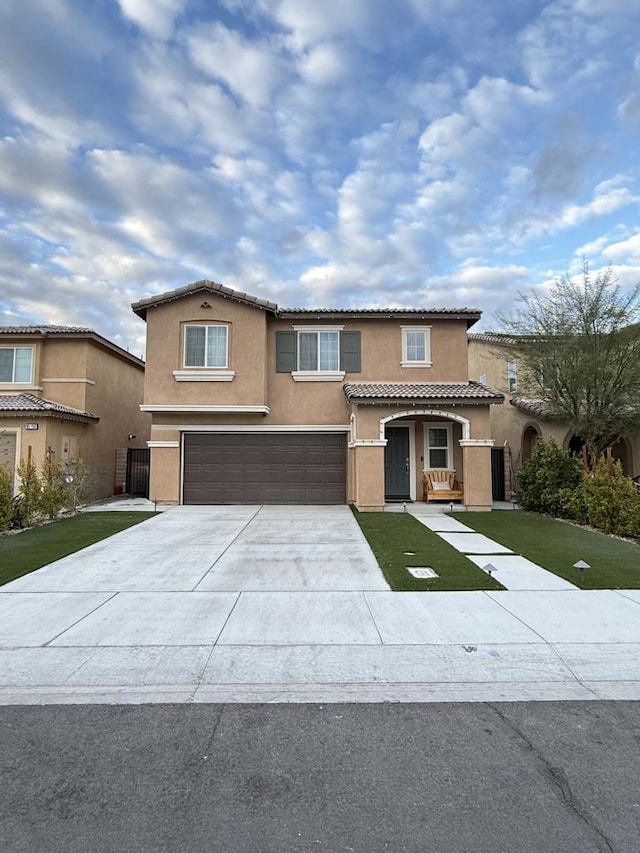 mediterranean / spanish-style house featuring a garage and a front lawn