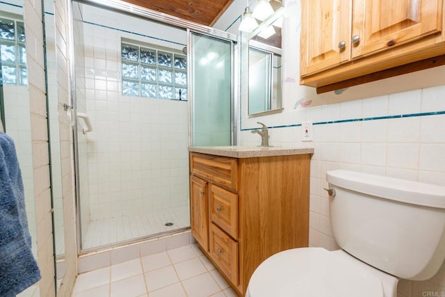 bathroom featuring vanity, tile walls, walk in shower, and toilet