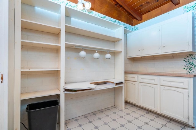 interior space with tasteful backsplash and white cabinets