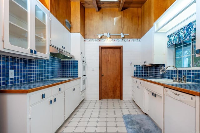 kitchen featuring sink, white cabinetry, beamed ceiling, white appliances, and backsplash