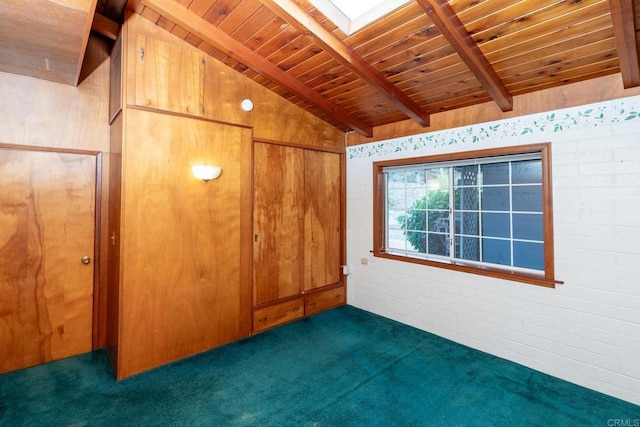 interior space with dark carpet, lofted ceiling with skylight, wooden ceiling, and brick wall