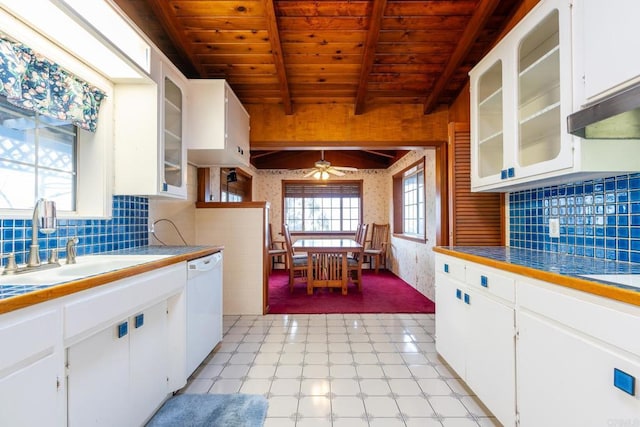 kitchen featuring white cabinetry, white dishwasher, sink, and beamed ceiling