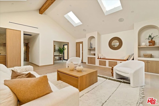 living room featuring built in shelves, a skylight, high vaulted ceiling, light wood-type flooring, and beamed ceiling