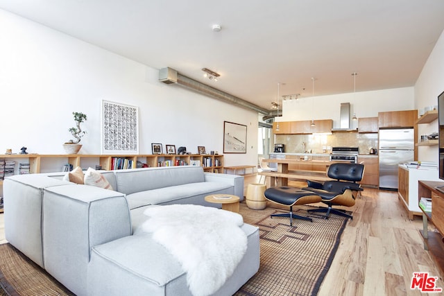 living room featuring sink and light hardwood / wood-style floors