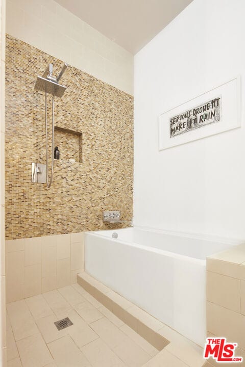 bathroom with tiled bath and tile patterned flooring