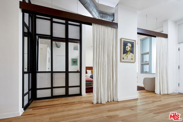 entryway with light hardwood / wood-style floors and a high ceiling