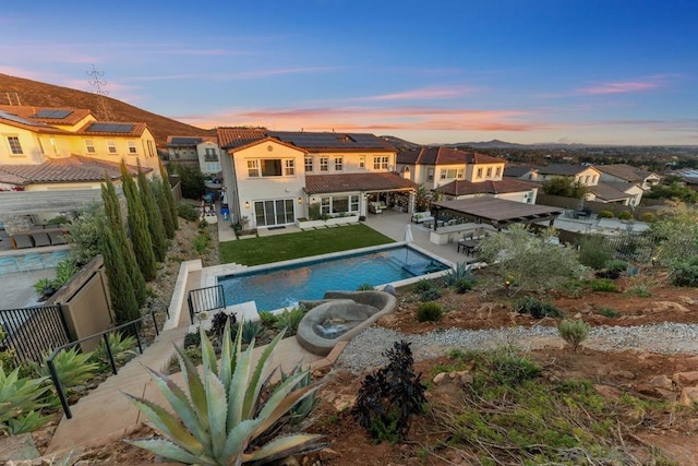 pool at dusk with a patio area