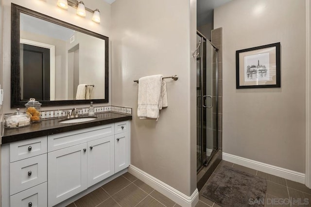 bathroom with tile patterned floors, vanity, and a shower with door