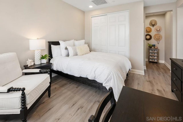 bedroom with light hardwood / wood-style floors and a closet