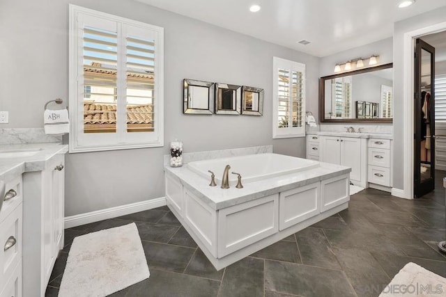 bathroom featuring tile patterned flooring, vanity, and a tub