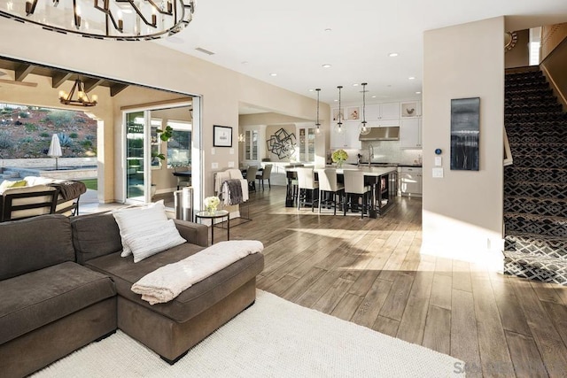 living room featuring wood-type flooring and a chandelier