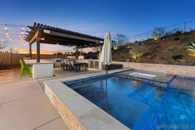 pool at dusk with a patio, a bar, exterior kitchen, an in ground hot tub, and a pergola