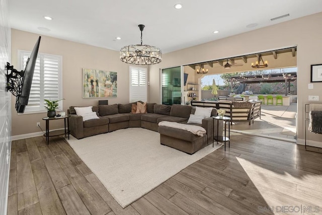 living room with hardwood / wood-style flooring and a notable chandelier