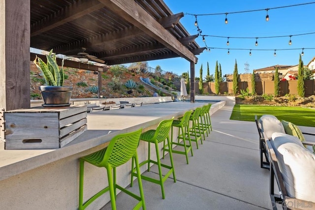 view of patio / terrace featuring exterior bar, ceiling fan, and a pergola