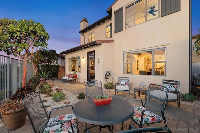 back house at dusk with a patio