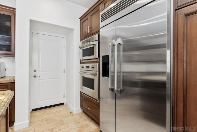 kitchen with appliances with stainless steel finishes and light stone countertops